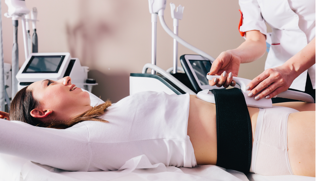 Ems sculpting machine, Woman with toned abdominals wears black exercise wear